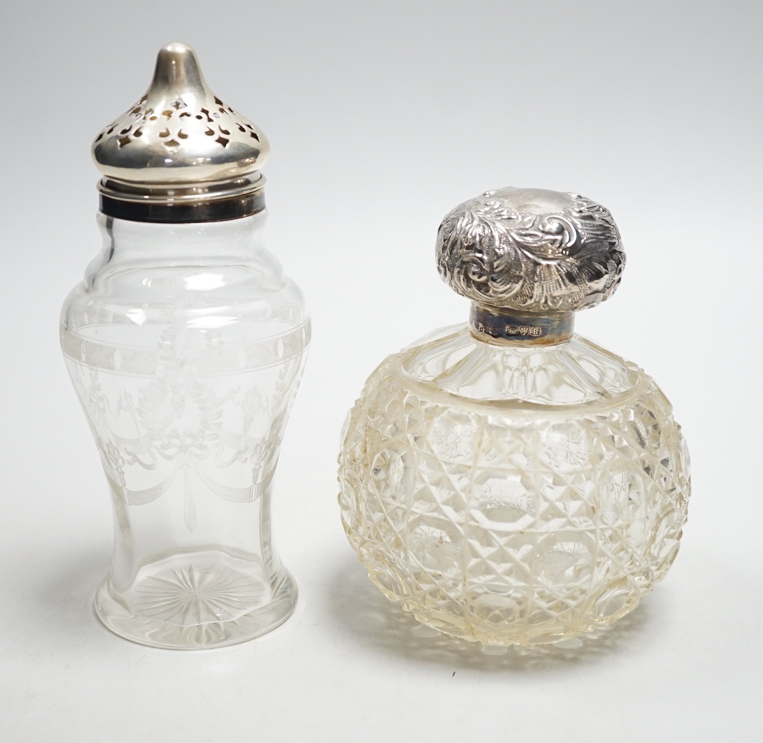 A late Victorian repousse silver mounted cut glass scent bottle, Chester, 1900, 13cm and a silver mounted sugar caster.